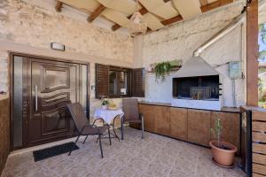 a patio with a table and chairs and a kitchen at Chara Stone House in Kharasón