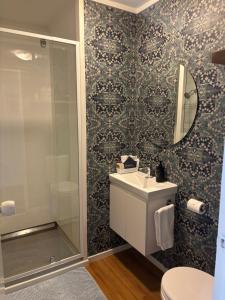 a bathroom with a sink and a shower and a mirror at The Opera View Suite in Oamaru