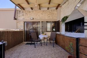 a patio with chairs and a table in a building at Chara Stone House in Kharasón