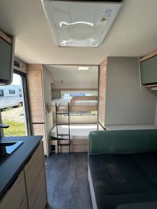 a room with a bedroom and a bed in a trailer at HelloHel klimatyzowane przyczepy Jastarnia Surf Kite Wind in Jastarnia