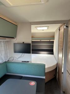 a small room with a bed and a tv at HelloHel klimatyzowane przyczepy Jastarnia Surf Kite Wind in Jastarnia