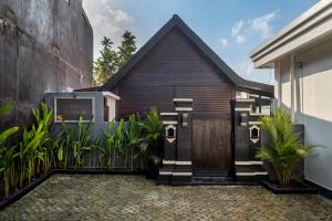 a house with a wooden door and some plants at Emy Kerobokan in Kerobokan