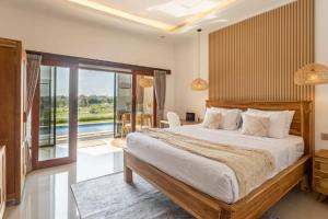 a bedroom with a large bed and a balcony at Emy Kerobokan in Kerobokan