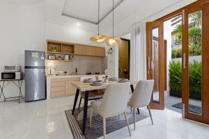 a kitchen and dining room with a table and chairs at KAUH House Canggu in Tumbak Bayuh