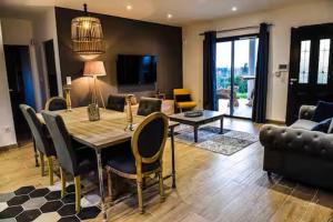 a living room with a table and chairs and a couch at Secret de campagne Spa in Grisolles