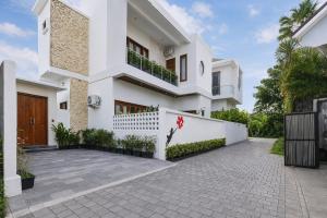 a white house with a courtyard in front of it at KAUH House Canggu in Tumbak Bayuh