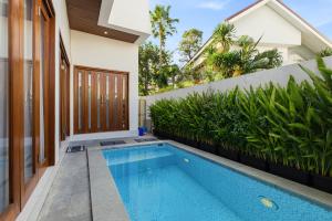 a swimming pool in the backyard of a house at KAUH House Canggu in Tumbak Bayuh