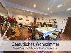 a living room with a table and a couch at EifelRuhe 2 - Komfortable Ferienunterkunft für bis zu 10 Gäste mit 4 Schlafzimmern, großer Küche und genug Parkplätzen - ideal für Gruppen und Familien, Hunde zulässig in Losheim