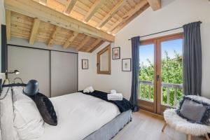 a bedroom with a bed and a large window at Chalet Niva by Mrs Miggins in Lens