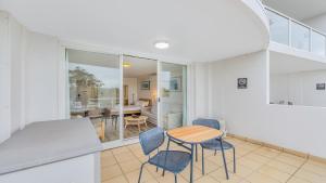 a kitchen and dining room with a table and chairs at Studio Oasis - Ettalong Beach Resort in Ettalong Beach