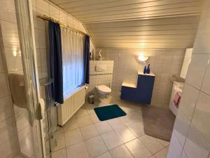 a bathroom with a toilet and a window at EifelRuhe 2 - Komfortable Ferienunterkunft für bis zu 10 Gäste mit 4 Schlafzimmern, großer Küche und genug Parkplätzen - ideal für Gruppen und Familien, Hunde zulässig in Losheim