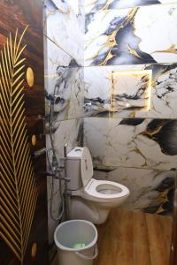 a bathroom with a toilet and a marble wall at The Aussie House in Mahabalipuram +22 photos