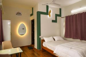 a bedroom with a bed with a green cross on the wall at The Aussie House in Mahabalipuram