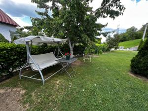 a chair and an umbrella and a table in a yard at Apartmani Ivana in Prozor