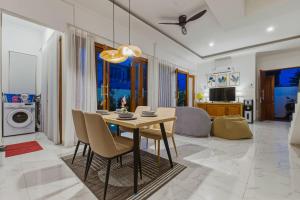 a dining room with a table and chairs in a living room at KAUH House Canggu in Tumbak Bayuh
