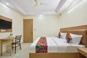 a bedroom with a bed and a desk and a television at FabHotel Dwarka Heritage in New Delhi +19 photos