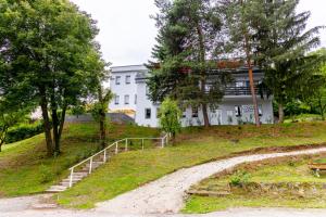 a building on a hill with stairs and trees at Penzión Stálica in Bojnice