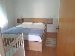 a small bedroom with a bed and a staircase at Apartman Mira Sabunike 1 in Privlaka