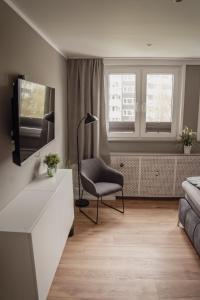 a living room with a couch and a chair and a television at Apartment Claussen 2 in Bremerhaven