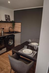 a kitchen with a table with plates and wine glasses at Apartment Claussen 2 in Bremerhaven