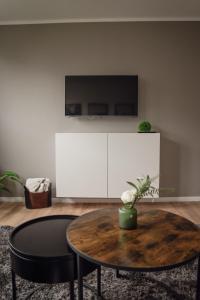 a living room with a table and a tv at Apartment Claussen 2 in Bremerhaven +6 photos
