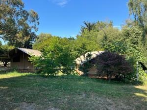 a house in the middle of a field with trees at Camping Onlycamp les etangs in La Richardais