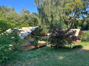 a house with a porch in a yard at Camping Onlycamp les etangs in La Richardais
