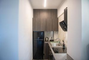 a kitchen with a black refrigerator and a sink at Well Being Luxury Apartments in Evdilos +136 photos