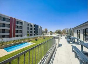 un balcón de un edificio con bancos y una piscina en Comfy 1 Bed 1 Bath En-Suite, en Chartwell