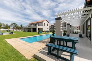 Un patio con dos bancos junto a una piscina. en Comfy 1 Bed 1 Bath En-Suite, en Chartwell