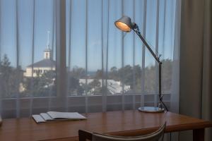 a desk with a lamp on a table with a window at Palanga Life Balance SPA Hotel in Palanga