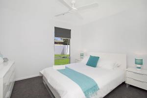 a white bedroom with a bed and a window at Buena Vista in Gold Coast