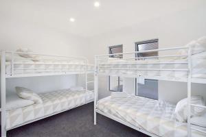two white bunk beds in a room at Buena Vista in Gold Coast