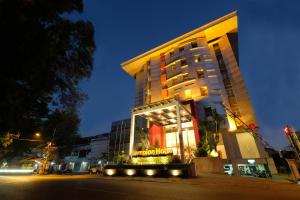 a large building with a sign in front of it at Lampion Hotel Solo in Grogol
