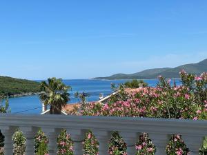 a balcony with flowers and a view of the water at Kalina in Bigova +8 photos