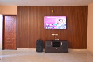 a room with a screen with a tv on a wall at Auro Green Villa in Pondicherry