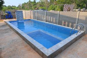a large swimming pool with blue water in a yard at Auro Green Villa in Pondicherry