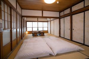 a large bed in a room with a window at 富士と宿と Fuji to Yado to in Fujiyoshida