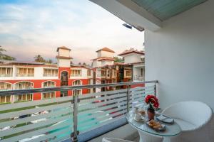 a balcony with a table and chairs and buildings at Hotel Shanti Solitaire, Arpora in Arpora