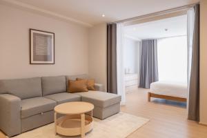 a living room with a couch and a bed at Taupe Hotel in Chiang Mai
