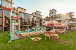 a resort yard with a slide and tables and umbrellas at Hotel Shanti Solitaire, Arpora in Arpora