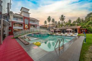 a bridge over a swimming pool at a resort at Hotel Shanti Solitaire, Arpora in Arpora