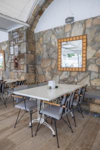 a table and chairs in a room with a stone wall at Sunpoint Hotel Bodrum in Bodrum City