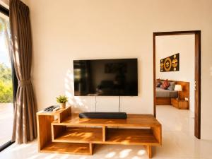 a living room with a flat screen tv on a wall at Mirari Villa in Wok Tum