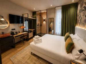 a bedroom with a large white bed and a kitchen at Saman Hotel Boutique in Valencia