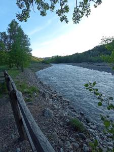 a wooden bench sitting next to a river at Il Bagatto B&B in Cavola