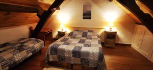 a attic bedroom with two beds and two lamps at Chez Nicole et Patrick in Chouvigny