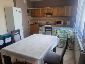 a kitchen with a white table and chairs and a refrigerator at Vikos-Spa in Rzeczyca