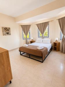 a bedroom with a large bed and two windows at Cliff Bay Hotel by GHH in Paleros +55 photos