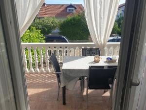 a table and chairs sitting on a balcony with a view at Apartman Mira Sabunike 1 in Privlaka